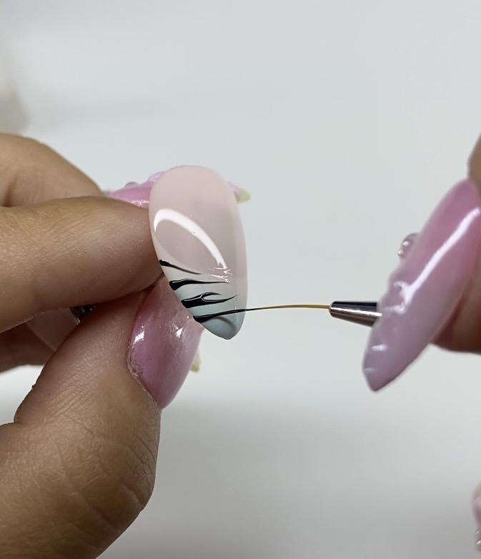 Hand-painting fine line nail art with a liner brush
